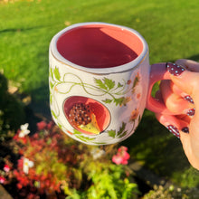 Person holding a mug with a floral design outdoors
