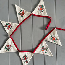 Decorative bunting with embroidered triangles on a gray wooden background