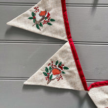 Triangular flags with embroidered designs on a gray surface
