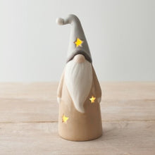 Ceramic gnome figurine with a gray hat and beige body on a wooden surface.